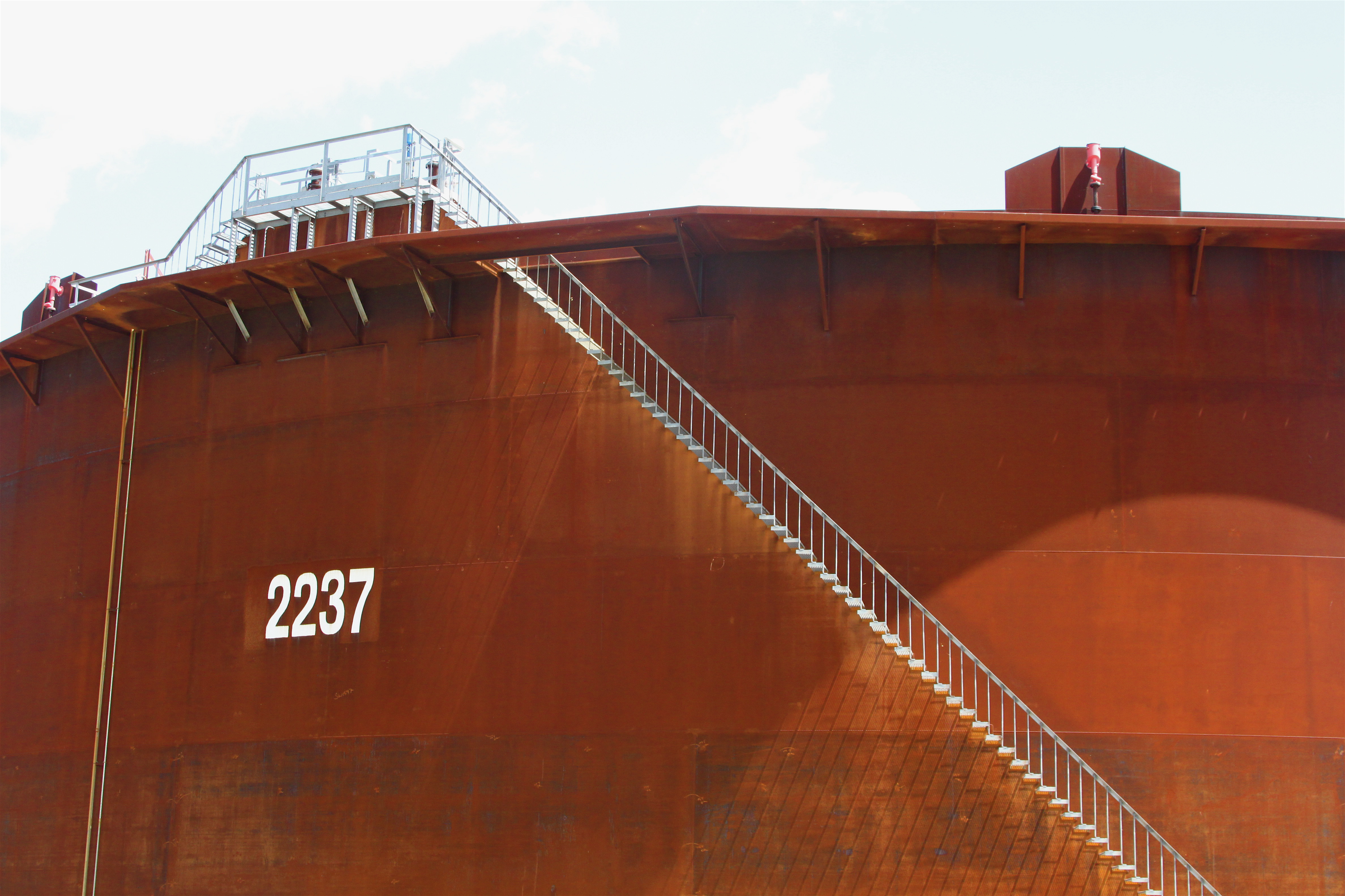 A large storage tank with an exterior staircase at the Enbridge tank farm in Cushing, Oklahoma.